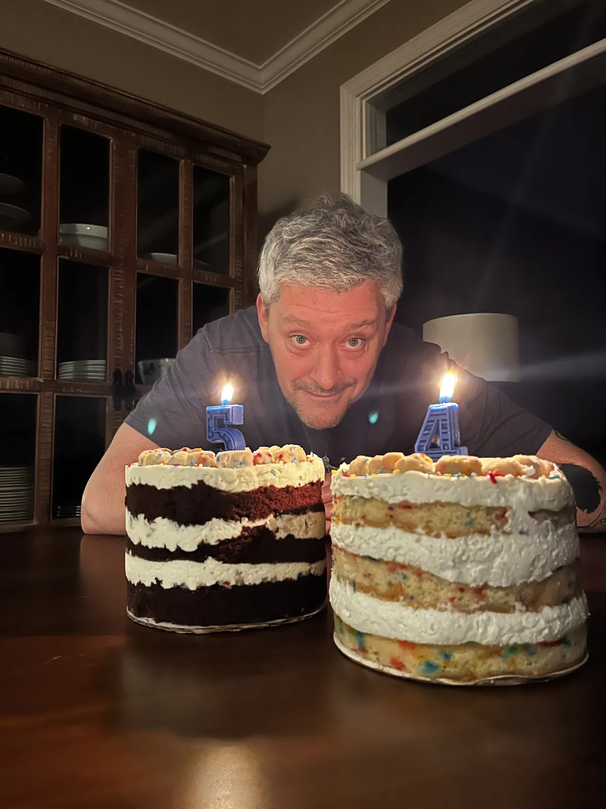 A Gen X UGC creator showcasing colorful Milk Bar birthday cakes on a table in a candid lifestyle shot.