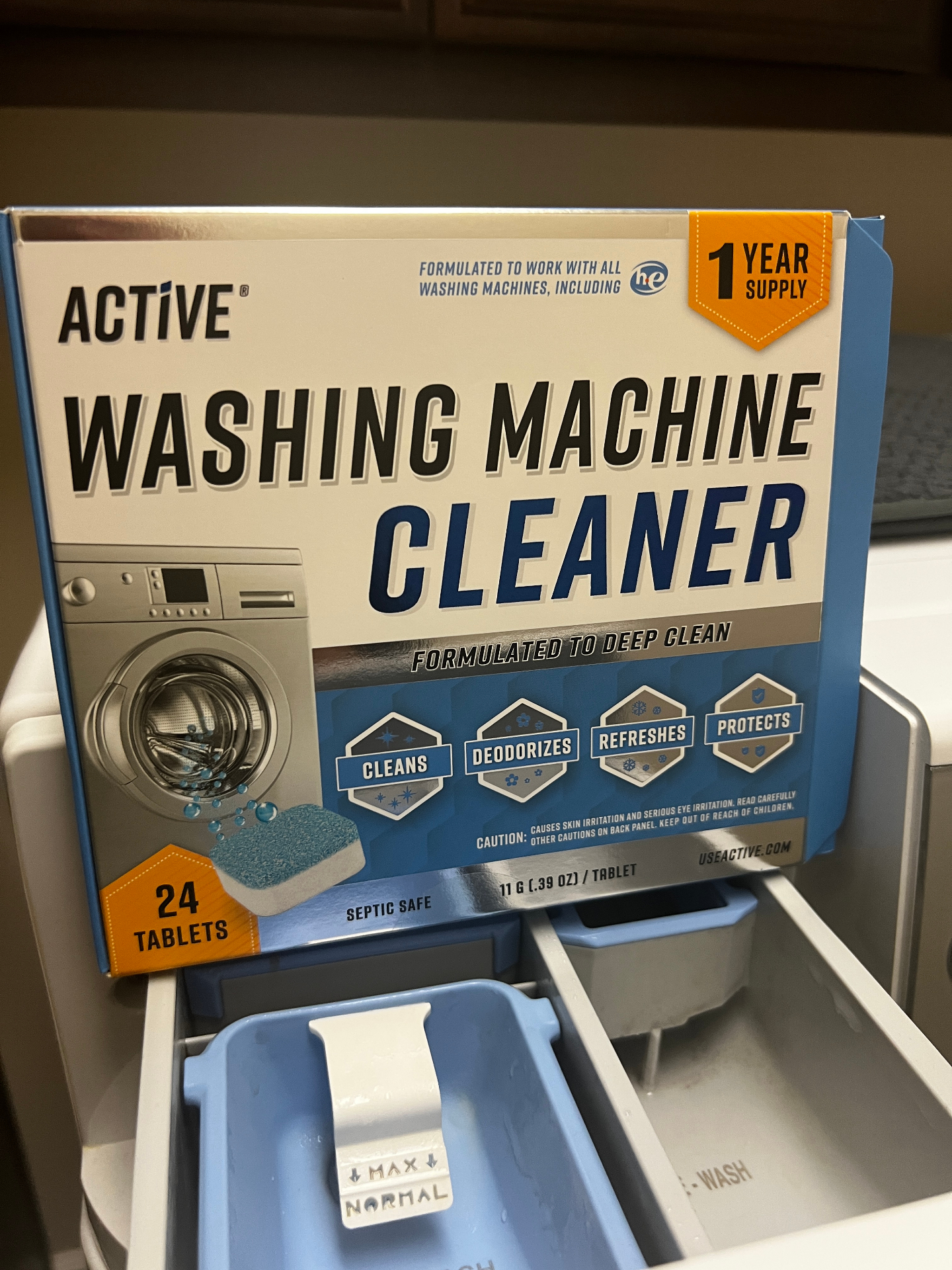 Product photography of an Active washing machine cleaner tablets box, one-year supply, staged on top of a washer.